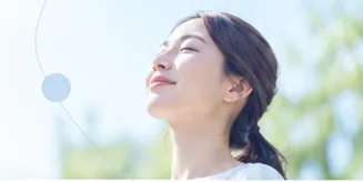 女性が空を見上げて深呼吸している様子