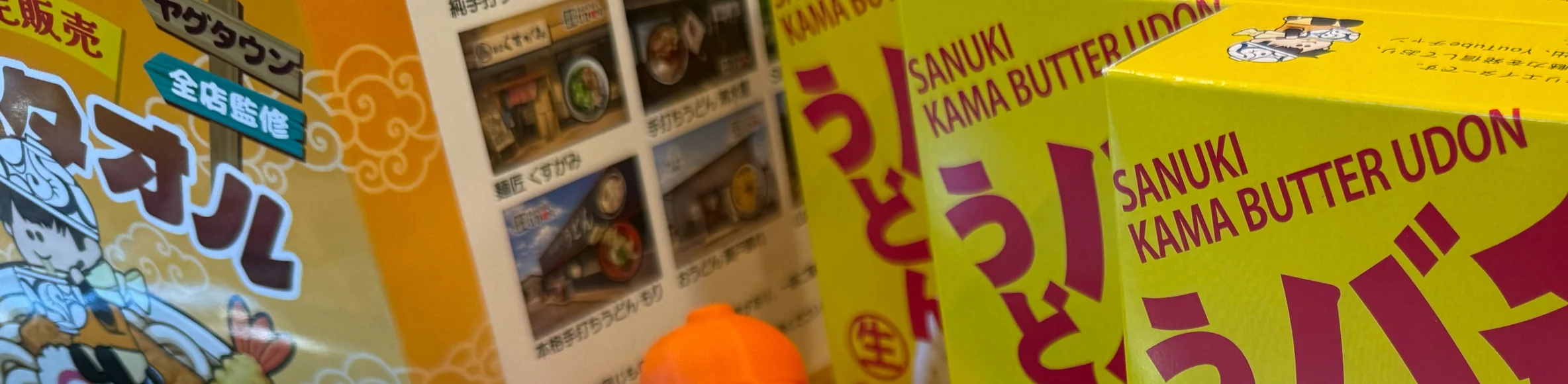 店頭に並ぶうどんタオルと監修商品の箱